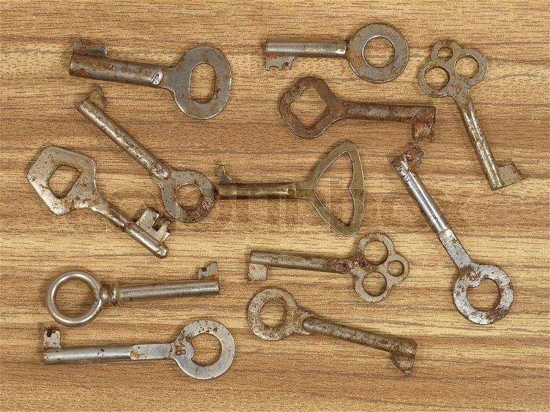 Old metal keys on a wooden table background, stock photo