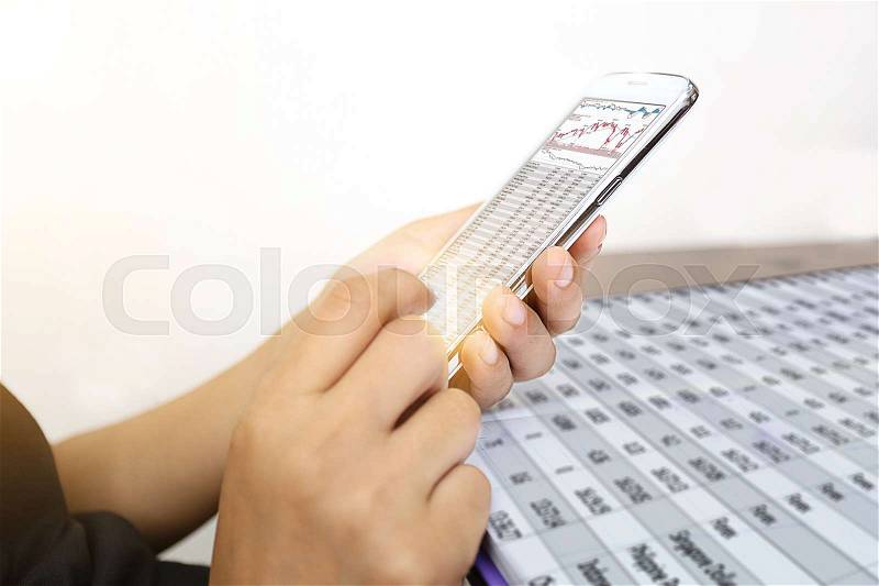 Business girl to check stock by mobile phone with trench graphic chart, stock photo