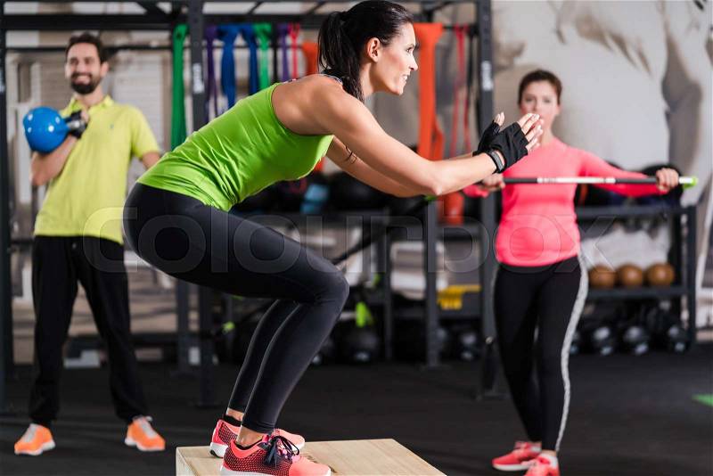 Group of men and woman in functional training gym doing fitness exercise, stock photo