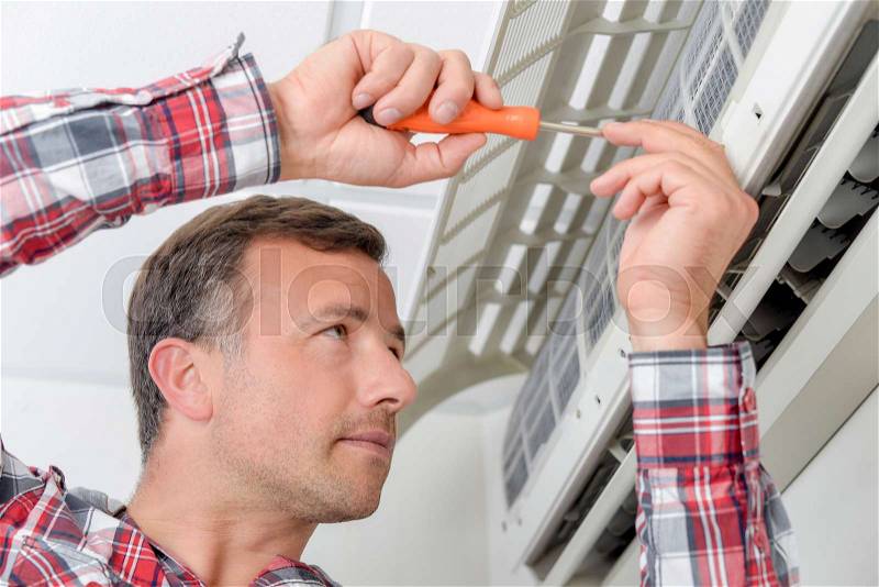 Trying to repair the air conditioning unit, stock photo