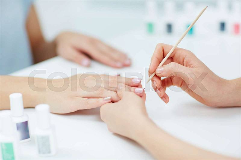 Woman hands receiving a manicure in beauty salon, stock photo