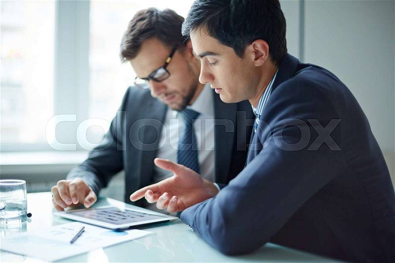 Two business colleagues discussing business plans on computer, stock photo