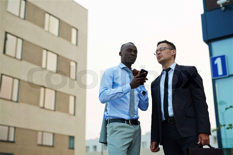 Elegant businessmen interacting in urban environment, stock photo