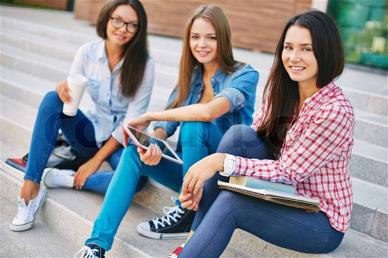 Portrait of high school students sitting on stairs outdoors, stock photo