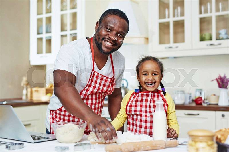 Portrait of happy family of two cooking together, stock photo