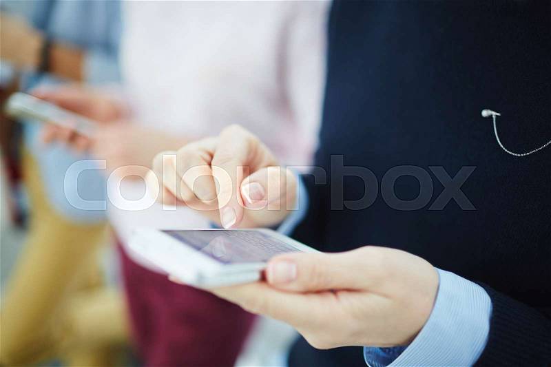 Close-up of female hands texting a message on the phone, stock photo