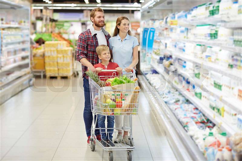 Parents and son buying food in supermarket, stock photo