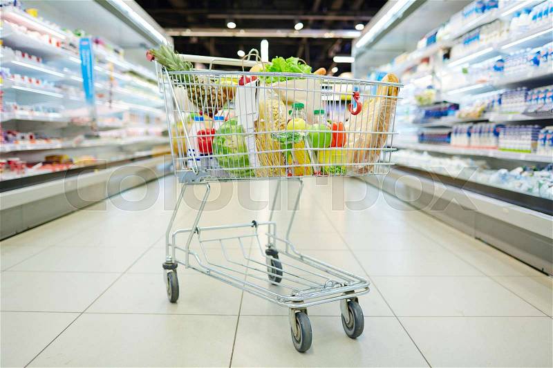 Consumer cart with products in supermarket, stock photo