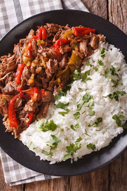 Latin American cuisine: ropa vieja with rice close-up on a plate. vertical view from above\, stock photo
