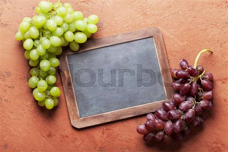 Red and white grapes and chalkboard for your text. Top view with copy space, stock photo