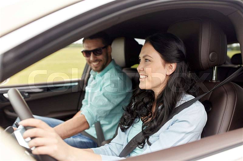 Leisure, road trip, travel, family and people concept - happy man and woman driving in car, stock photo