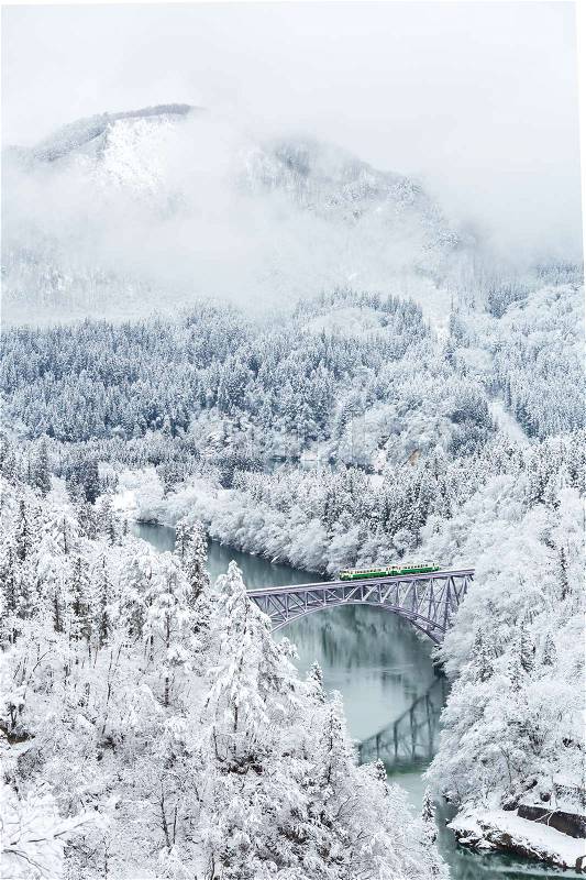 Winter landscape snow covered trees with train crossin River on Bridge, stock photo