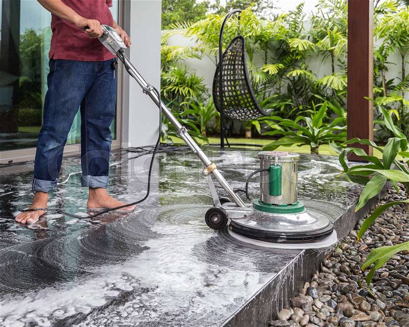 Exterior black stone floor cleaning with polishing machine and chemical, stock photo