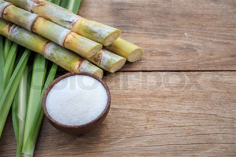 Top view white sugar and sugar cane and leaf on wooden background, stock photo