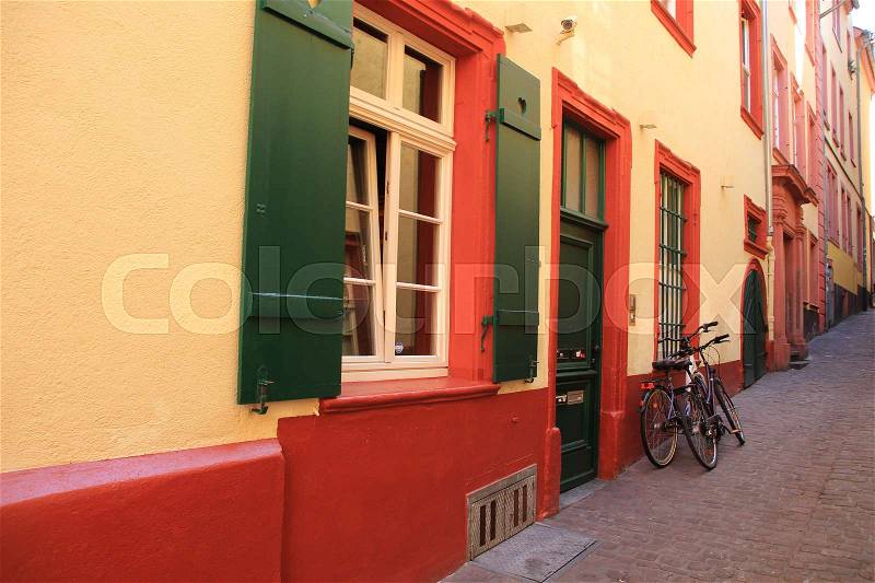Two bikes standing against the wall of the striking house in the residential area in the village Heidelberg in Germany in the wonderful summer, stock photo