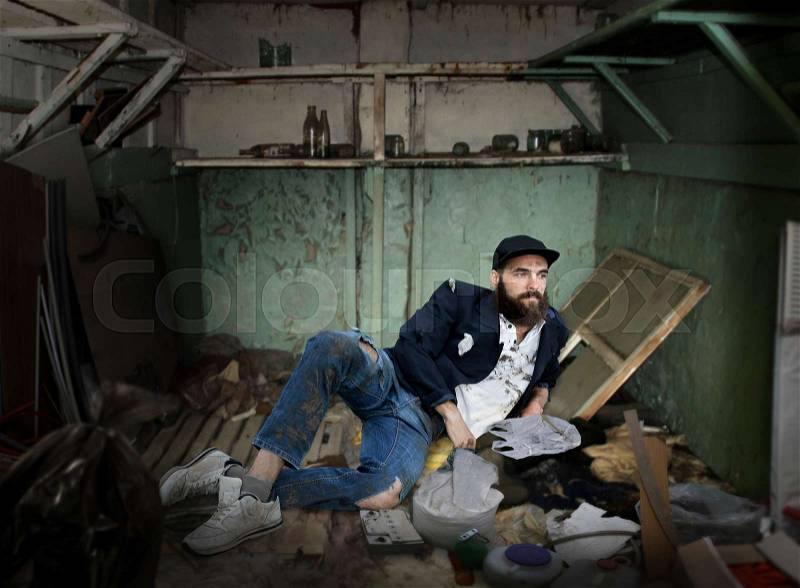 Vagrant lying in a dirty room, stock photo