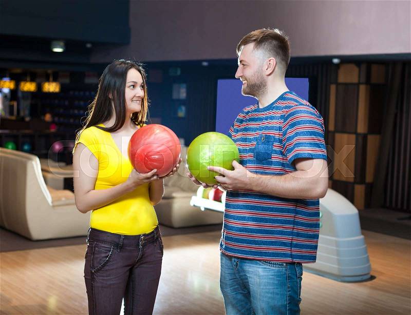 Smiling couple with bowling balls, stock photo