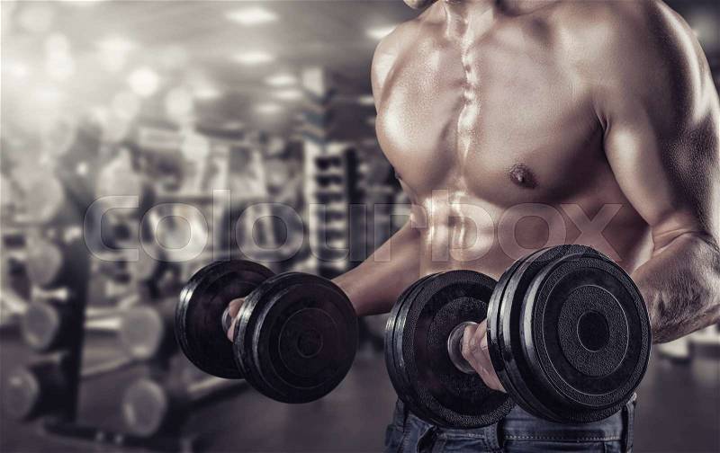 Closeup of a muscular young man lifting weights in the gym, stock photo