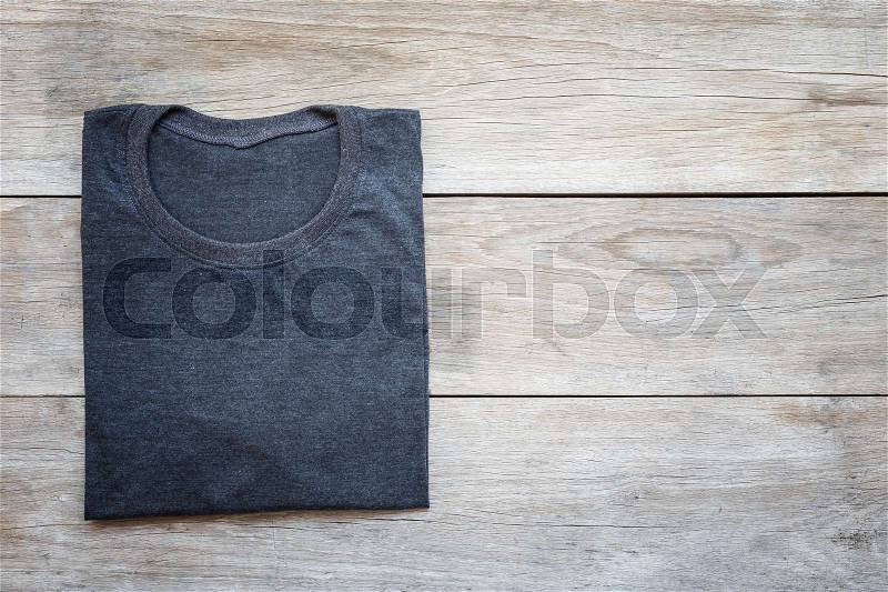 Top view of color T-Shirt on grey wood plank background, stock photo