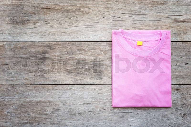 Top view of color T-Shirt on grey wood plank background, stock photo