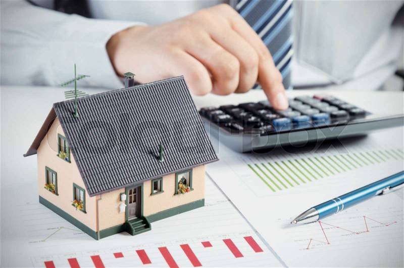 Businessman calculate the cost of building and maintaining house. Home finance conception, stock photo