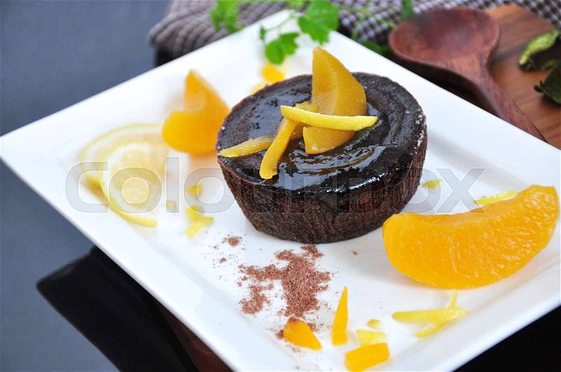 Chocolate lava cake topping with peach on white plate, stock photo