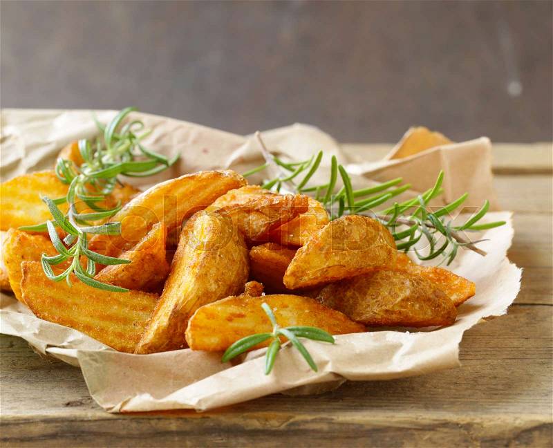 Slices of fried potatoes with rosemary and spices, stock photo