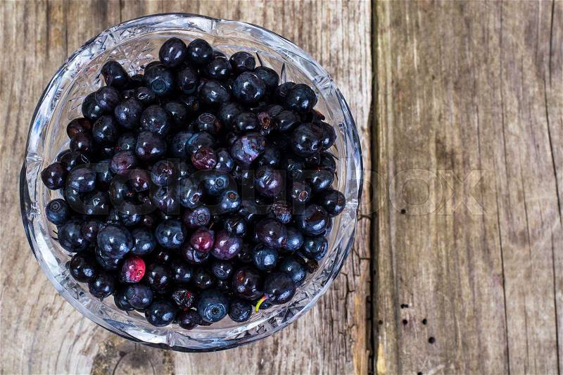 Bilberry in Crystal Bowl on Rustic Wooden Background, stock photo