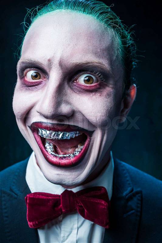Bloody Halloween theme: The crazy joker face on black background, stock photo