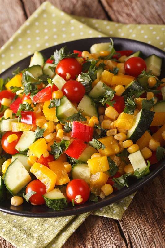 Fresh vegetable salad with corn, tomatoes, cucumbers and pepper close-up on the table. vertical\, stock photo