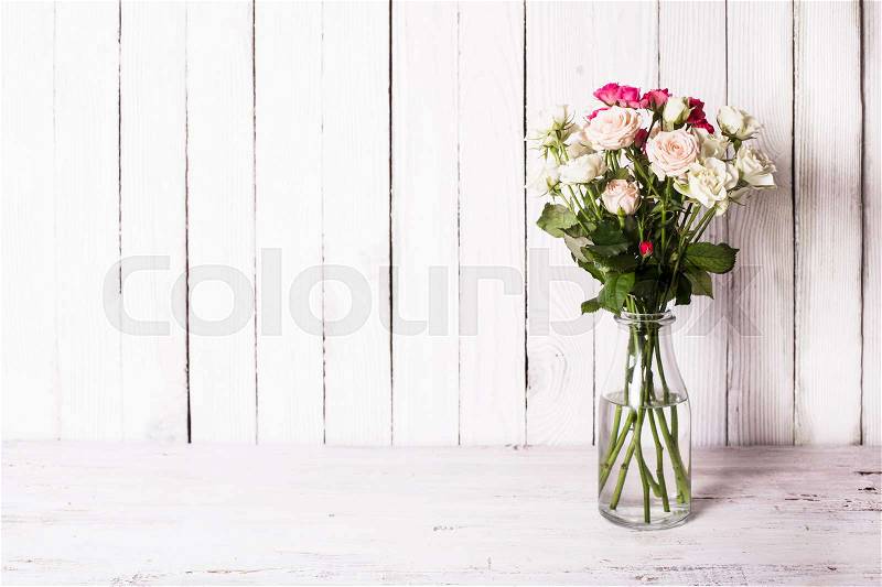 Luxury bouquet of roses lying over wooden wall. Copy space, stock photo