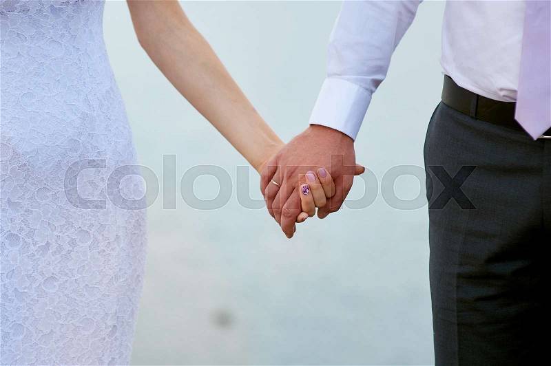 Wedding photo of bride and groom holding hands closeup, stock photo