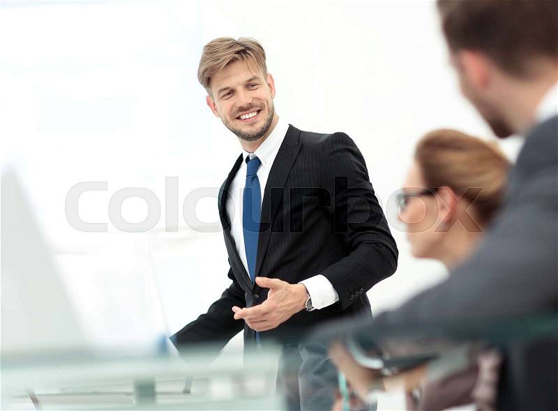 Successful business man in suit at the office leading a group, stock photo