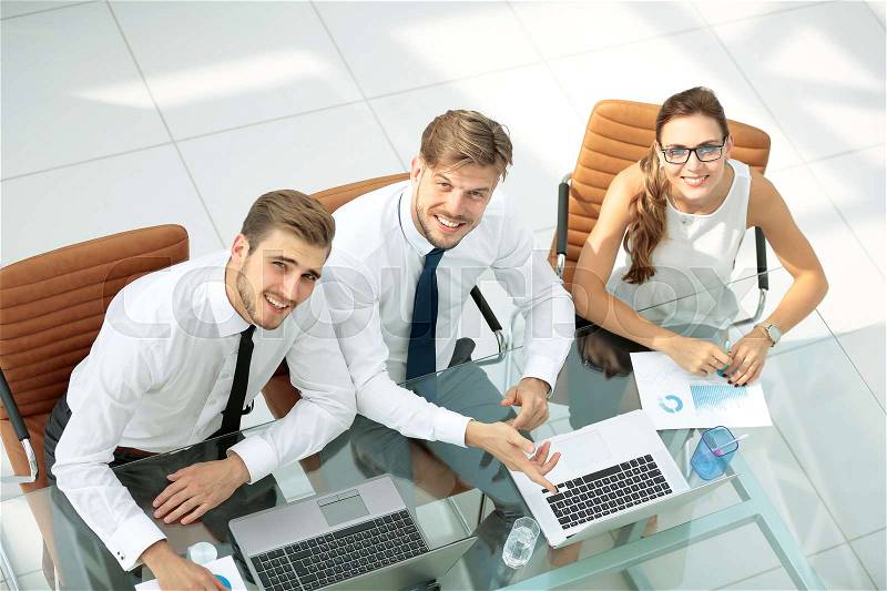 Three successful business person discussing. High view, stock photo