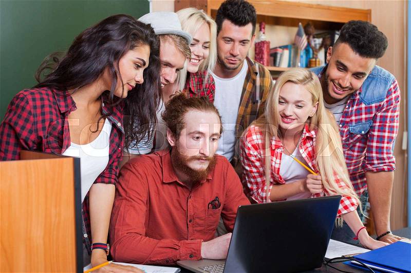 Student High School Group With Professor Using Laptop Computer Sitting At Desk, Young People Teacher Discuss Communicate University Classroom, stock photo