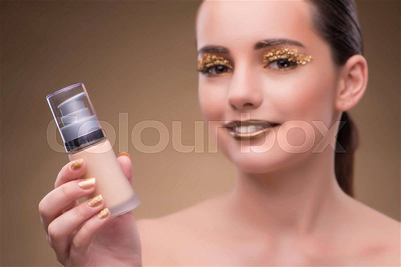 Woman with bottle of skincare cream, stock photo