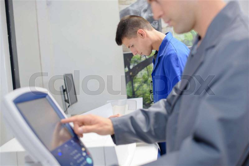 Man entering information on to electronic control pad, stock photo