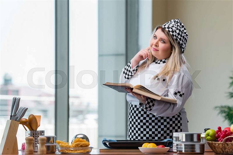 Young chef cook working in the kitchen, stock photo
