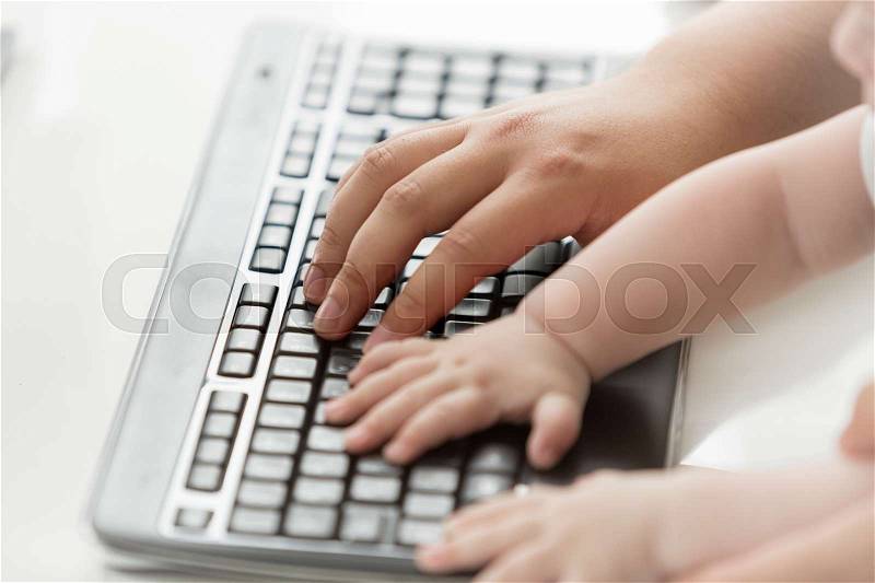 Closeup photo of father teaching his baby how to use computer keyboard. Concept of communications between generations, stock photo