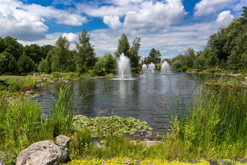 Beautiful landscape of pond with fountains at park at sunny day, stock photo