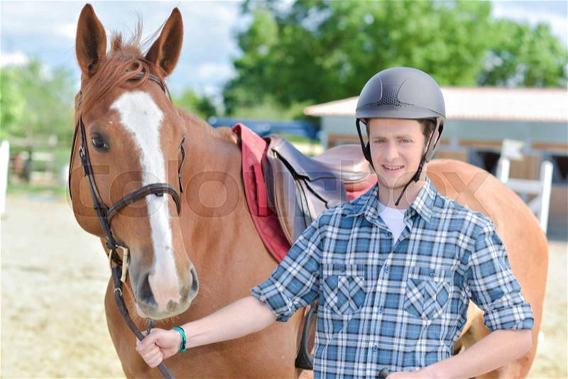 Portrait of young man with horse, stock photo
