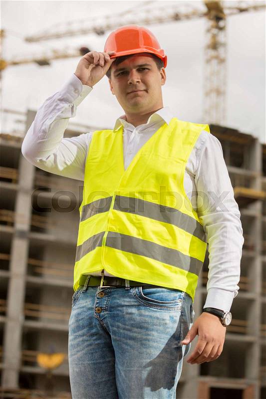 Toned closeup portrait of smiling construction engineer wearing hardhat, stock photo