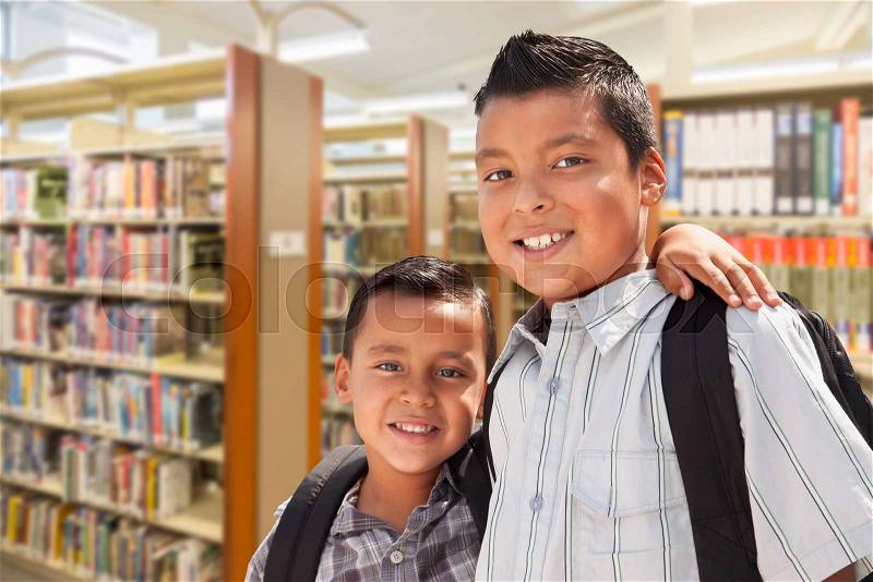 Happy Young Hispanic Student Brothers In Library, stock photo