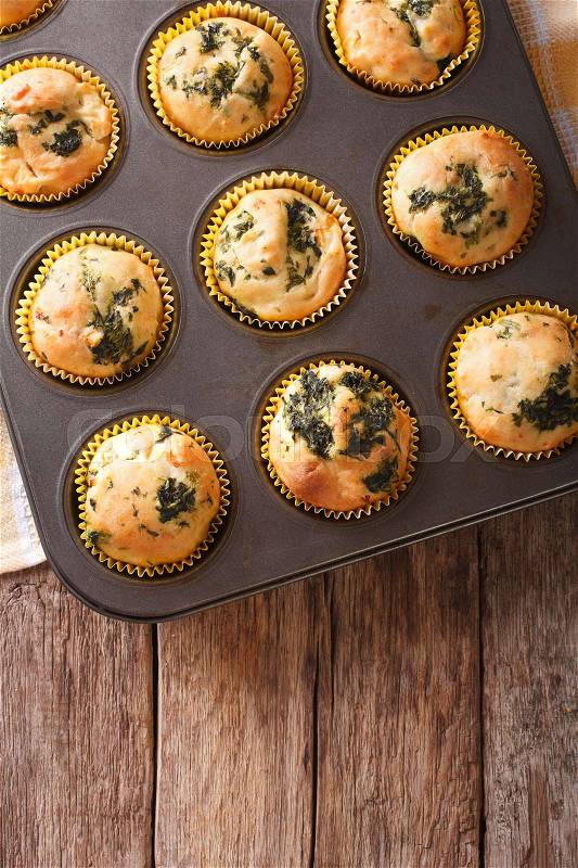Fresh from the oven muffins with spinach and feta cheese close-up on the table. vertical view from above\, stock photo