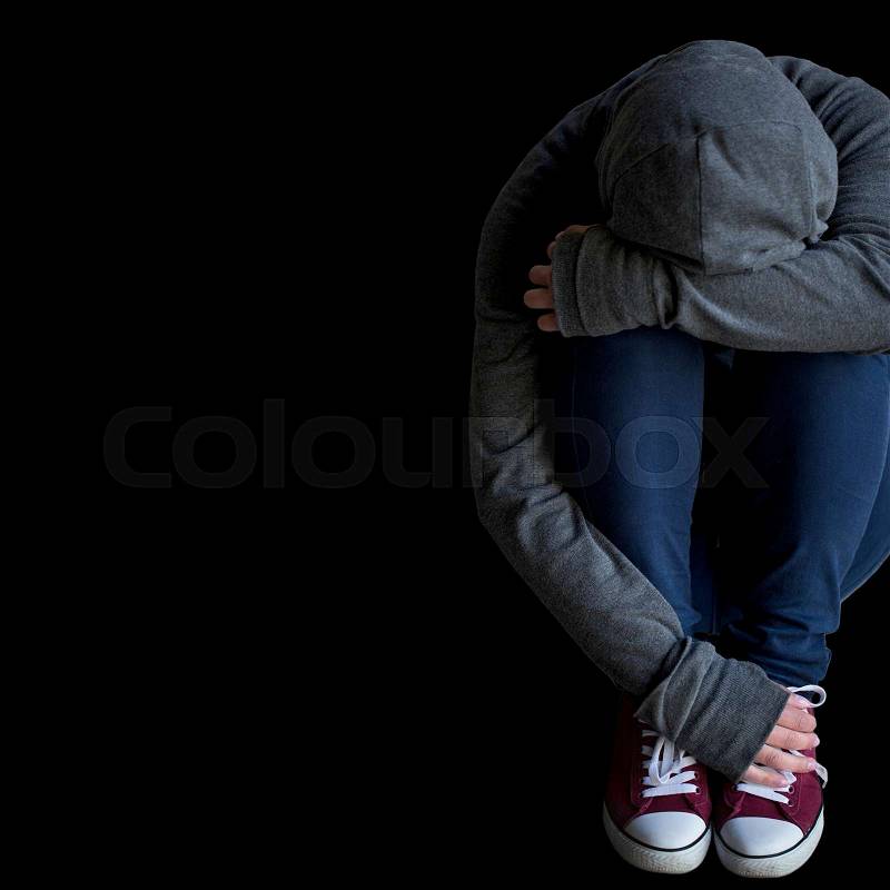 Depression, drug addiction, people and social issue concept - close up of person hiding her face over blank black background, stock photo