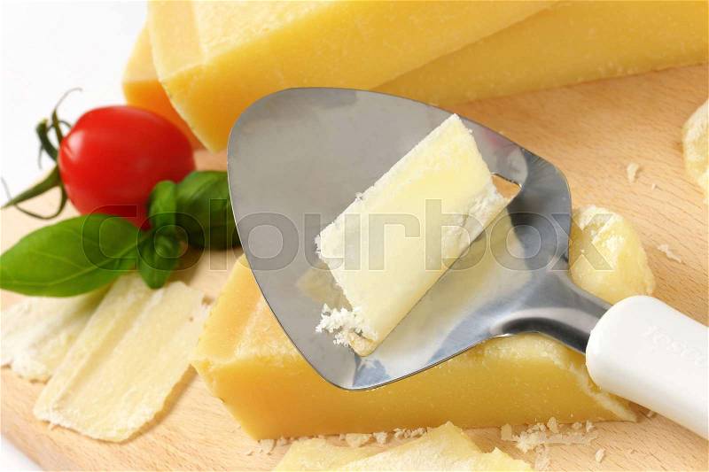 Close up of cheese knife on parmesan cheese, stock photo