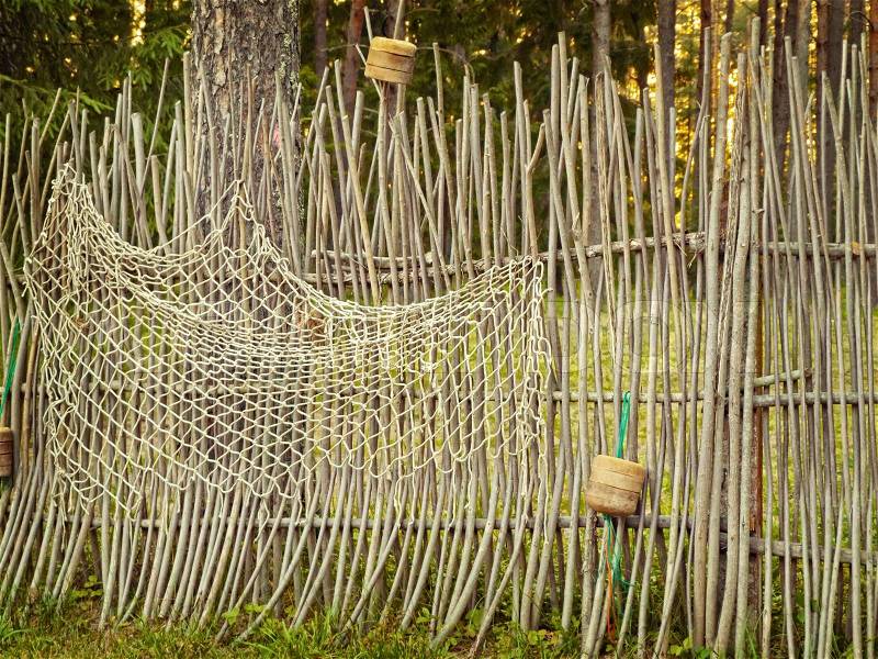 Fence with fishing net in the forest, stock photo