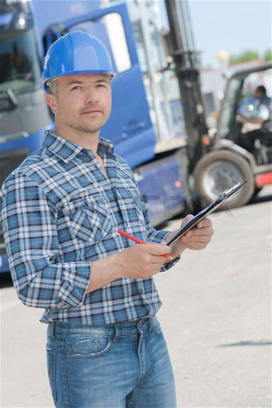 Portrait of worker with clipboard, stock photo
