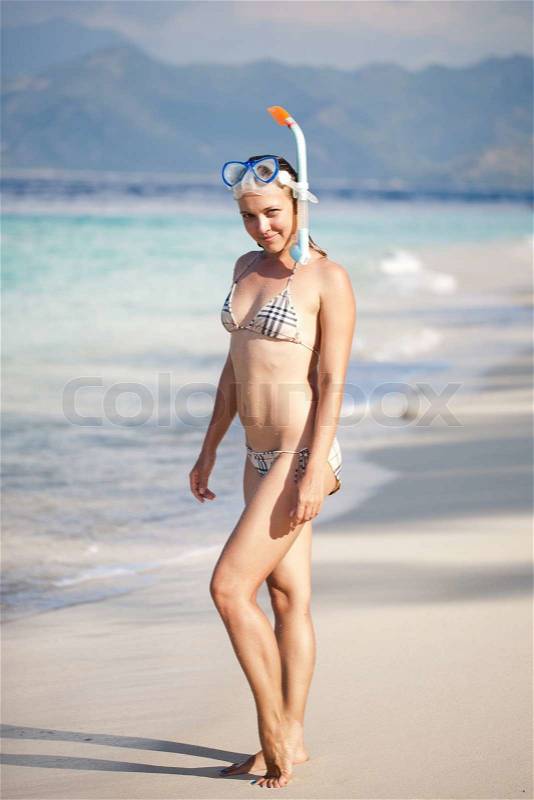 Woman with snorkeling gear on the beach, stock photo