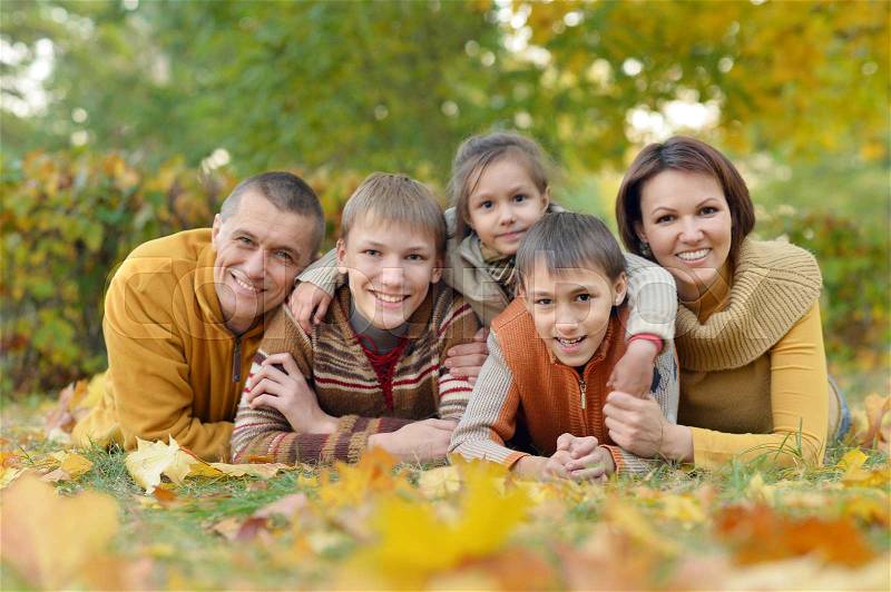 Happy smiling family relaxing in autumn park, stock photo